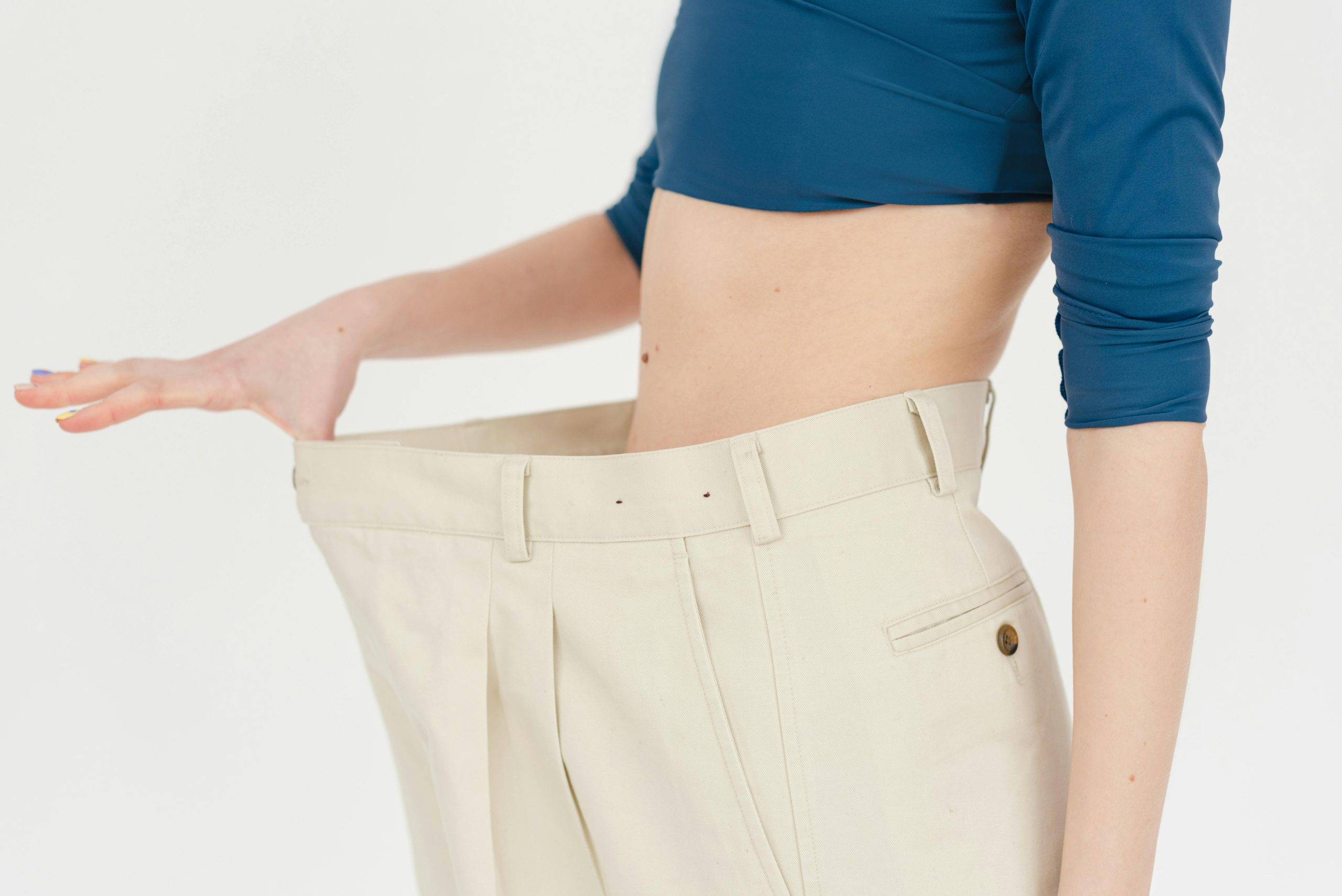 Person stretching out oversized pants from weight loss